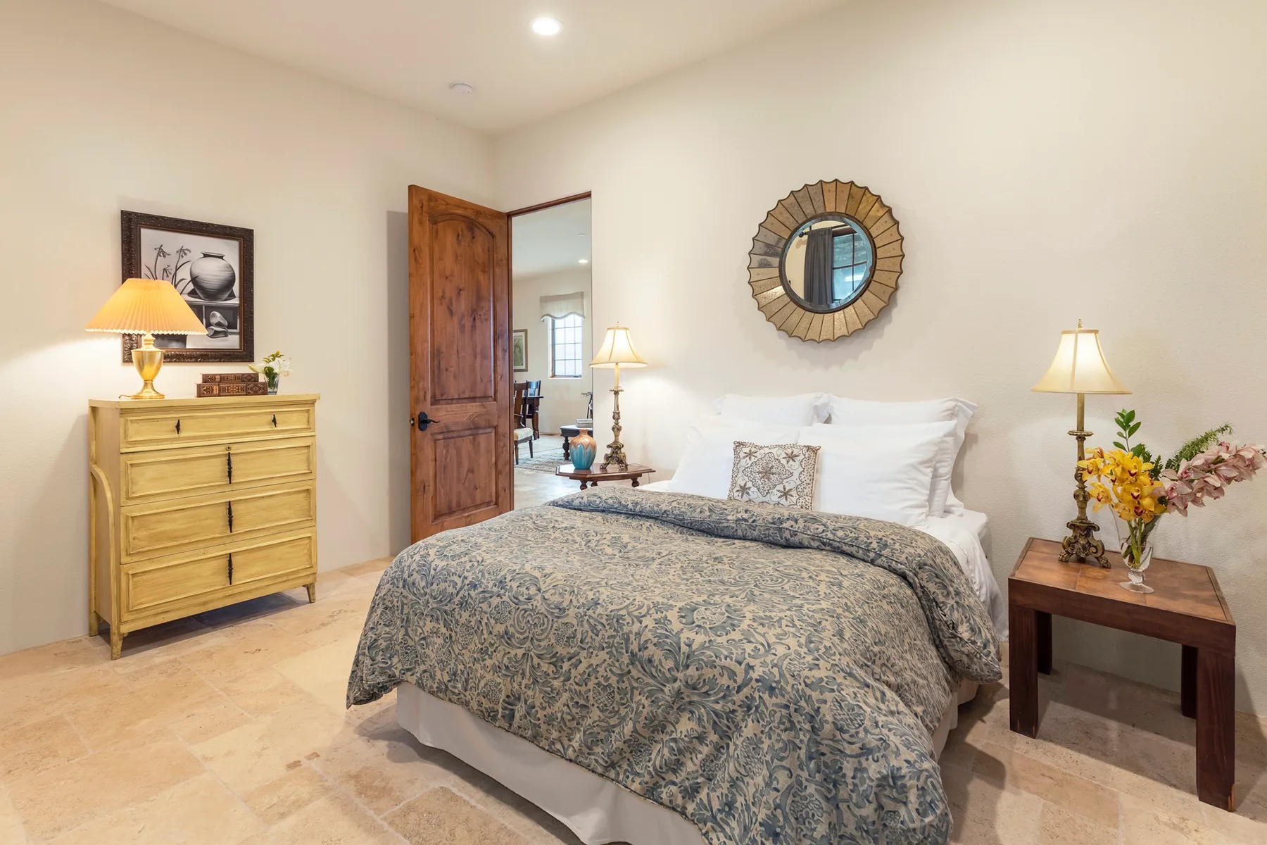 Un dormitorio con una cama bien tendida y una cómoda de madera.