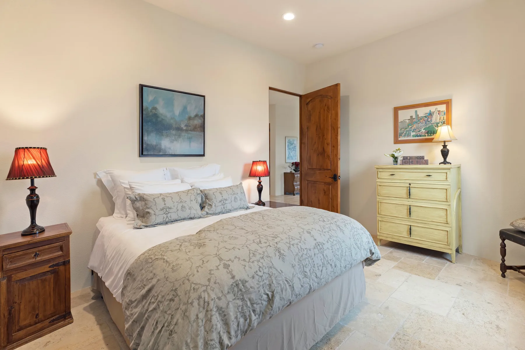 Un dormitorio con una cama bien hecha y una puerta de madera abierta.