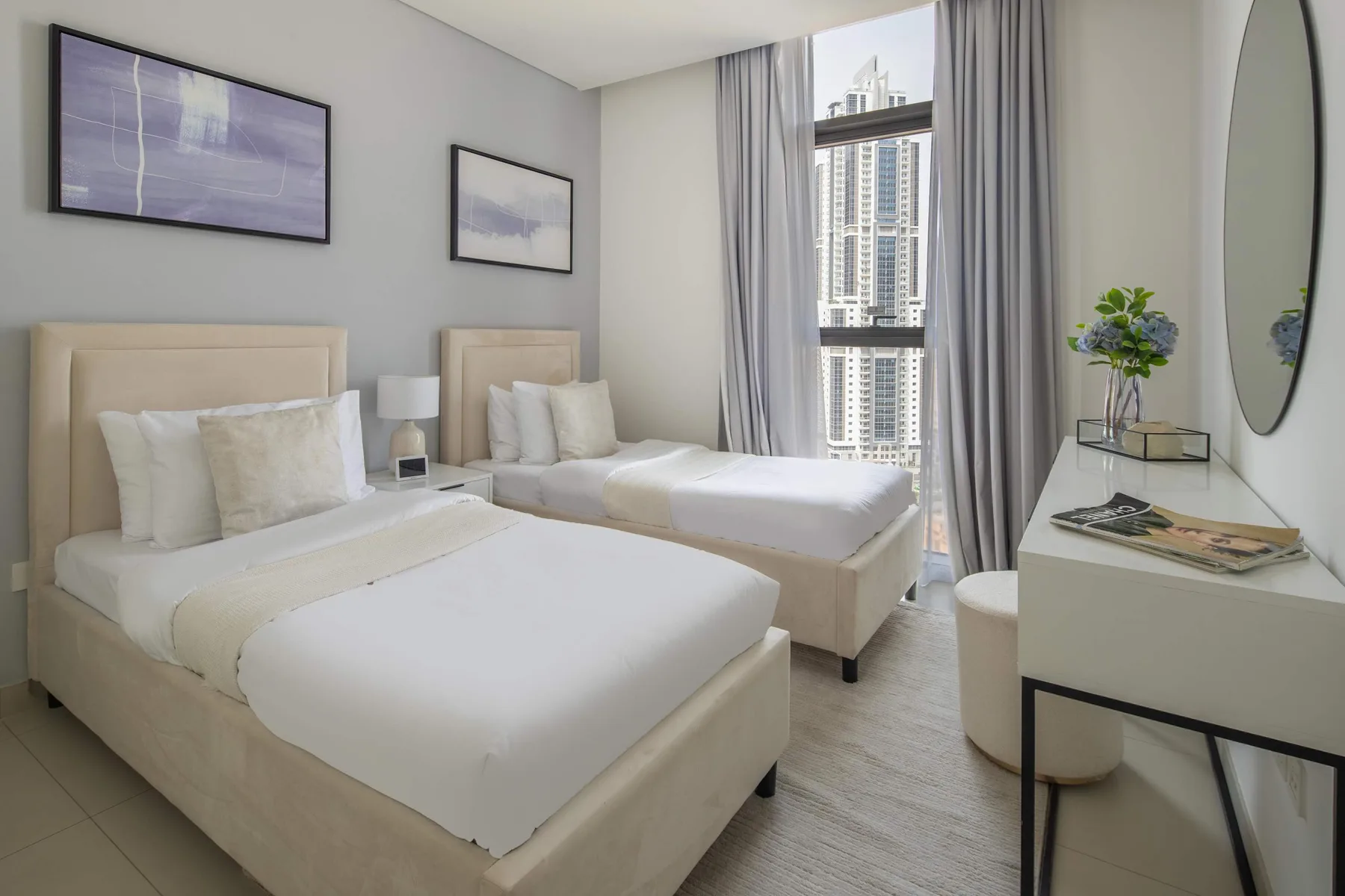Un dormitorio luminoso con dos camas tendidas junto a una ventana grande.