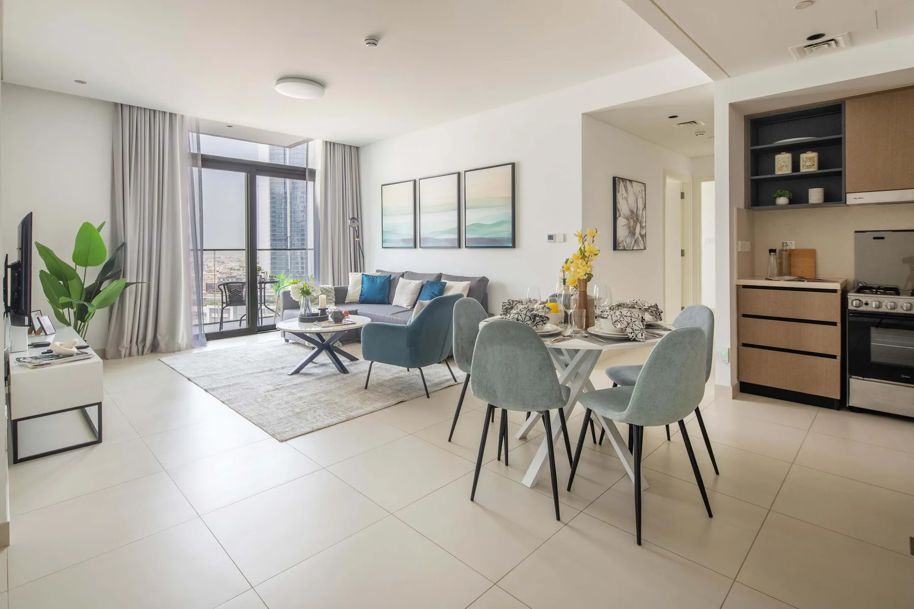 Una sala-comedor de planta abierta con cocina y grandes ventanales.