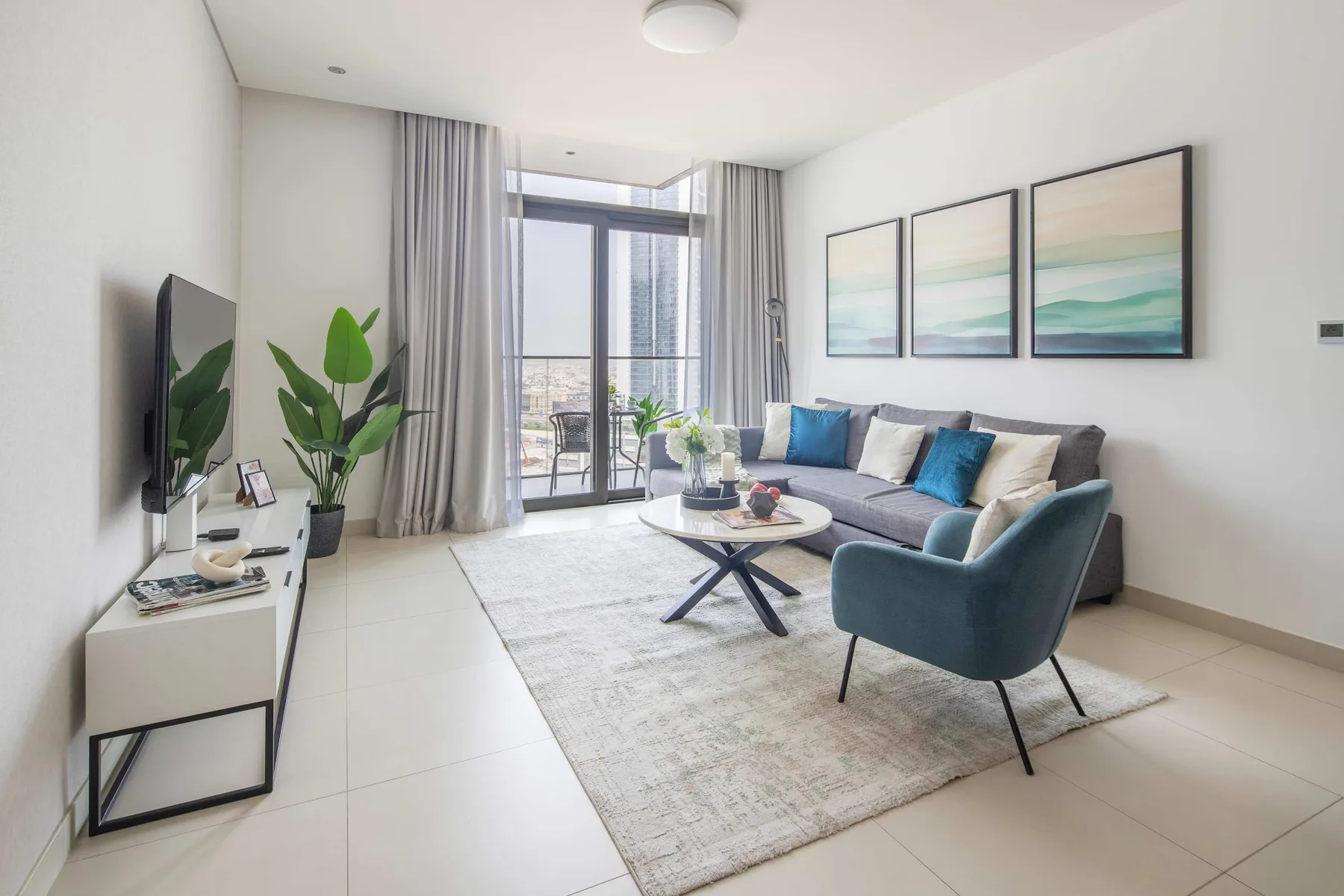 Sala de estar luminosa con sofá, sillón y una mesa de centro.