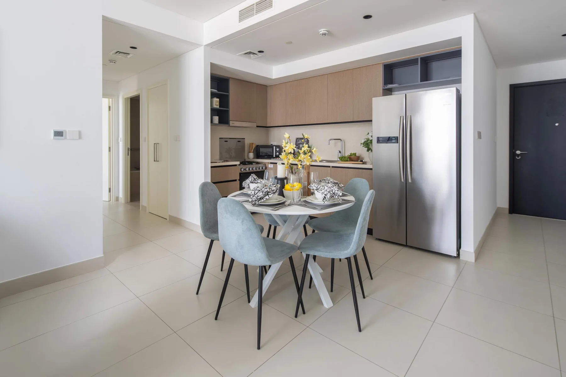 Comedor con la mesa puesta junto a una cocina abierta.