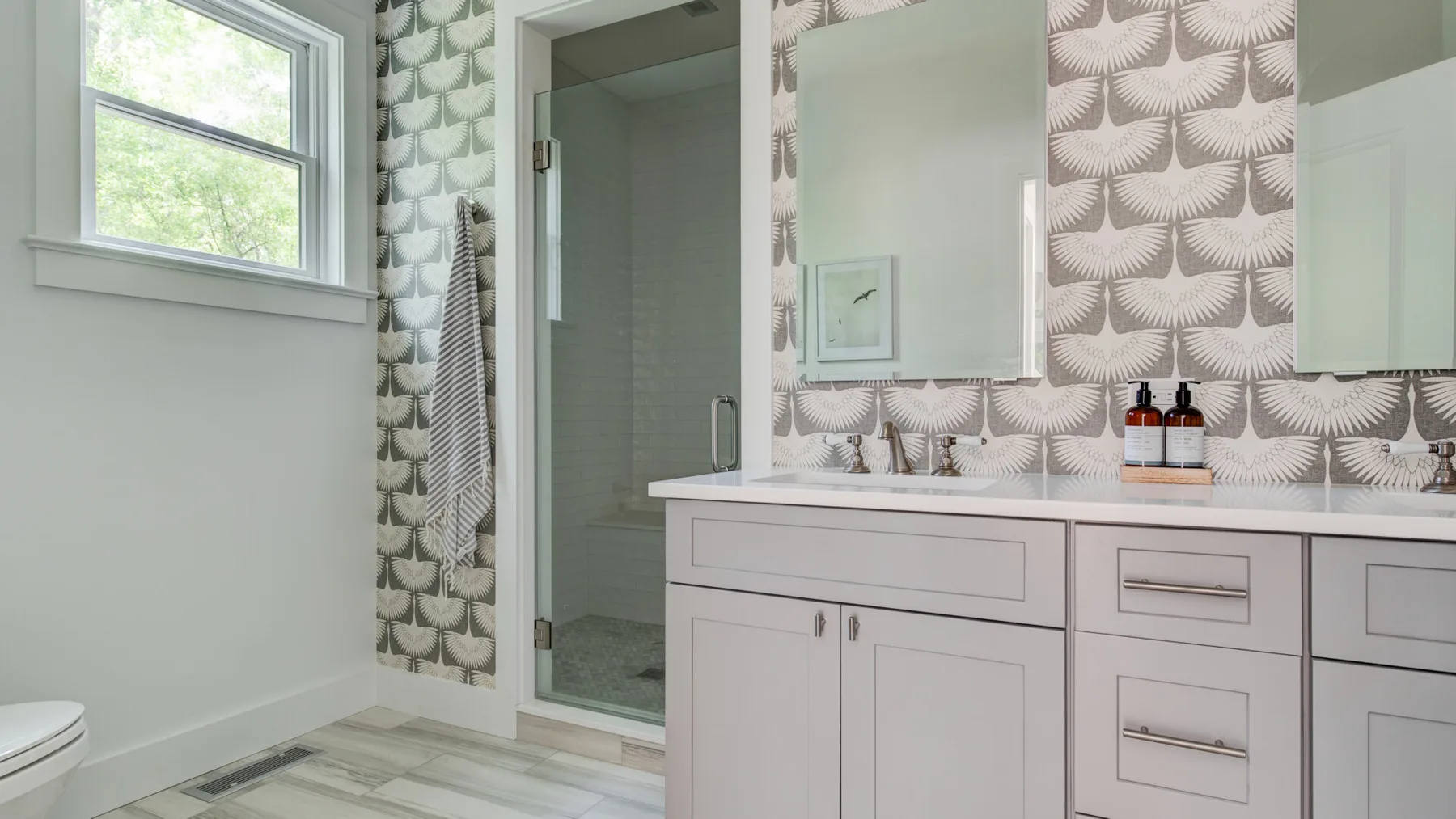 Se ven un mueble de baño y una ducha junto a una ventana.
