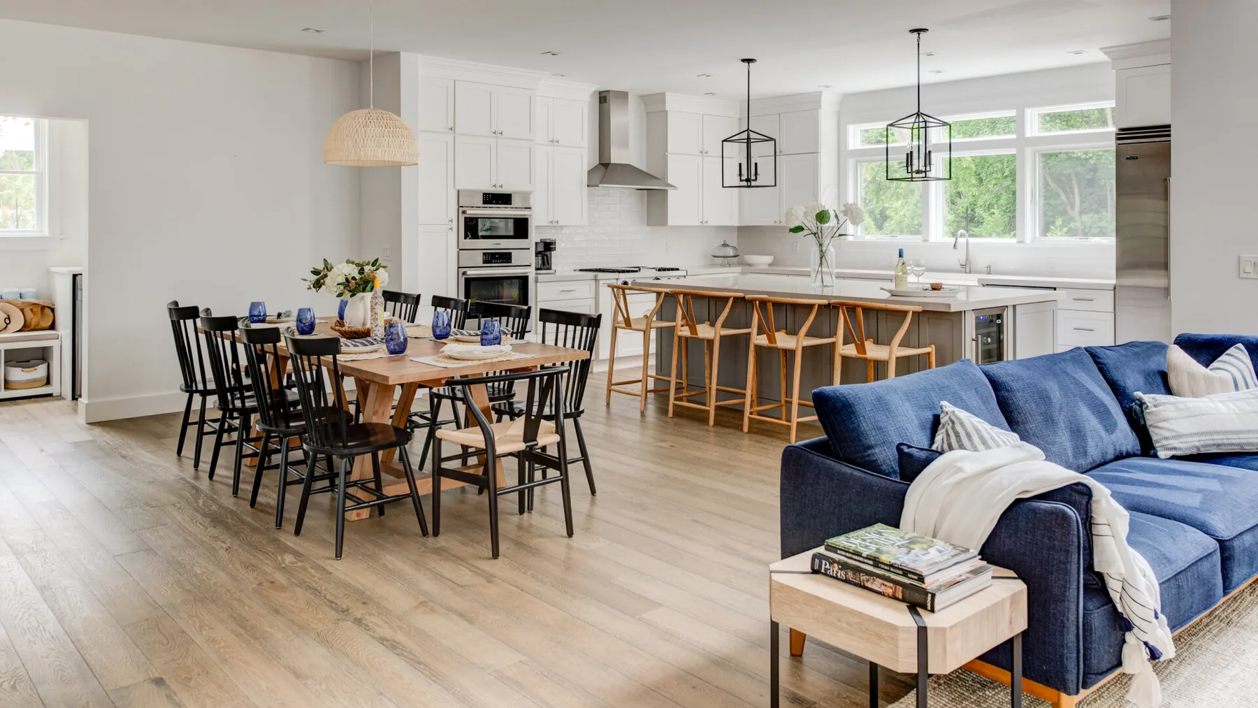 Una zona abierta de comedor y cocina con una mesa de comedor y asientos azules.