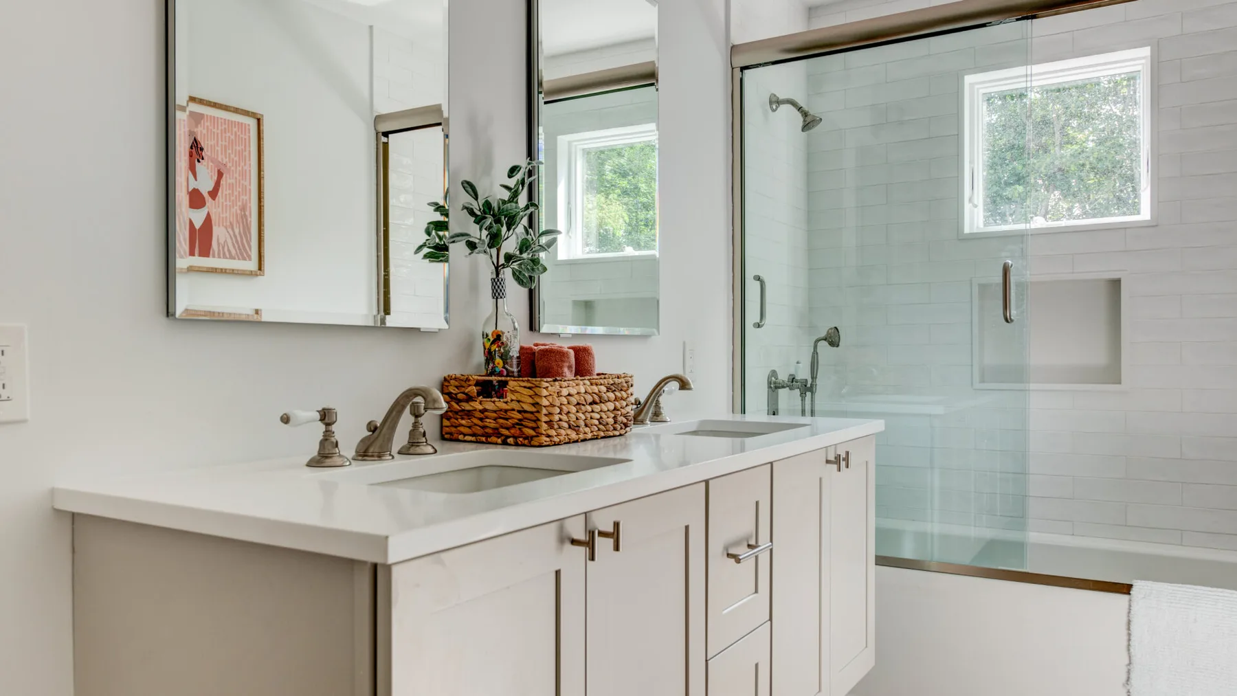 Un baño luminoso tiene un lavabo blanco y una ducha de cristal.