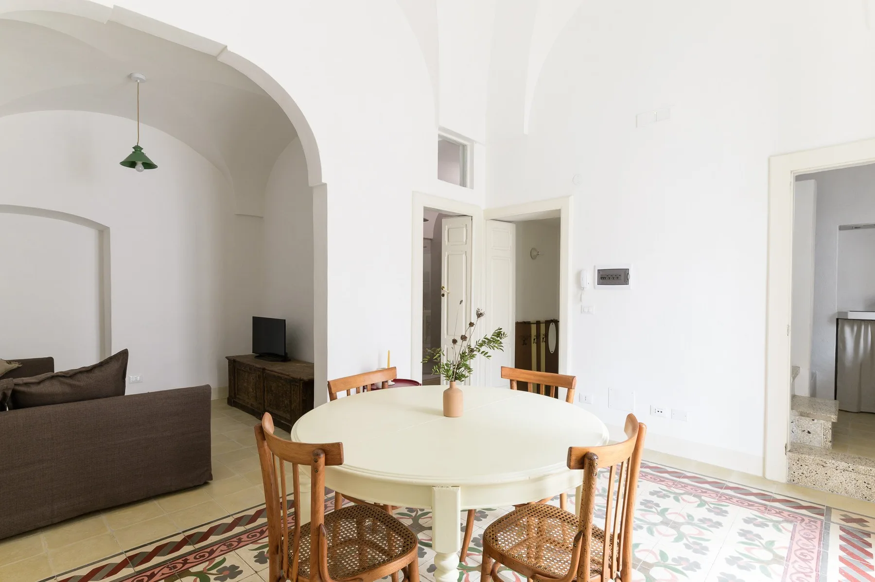 A bright dining area with a round table and wooden seating.