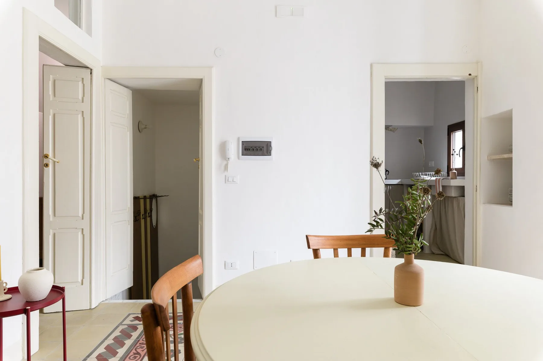 A bright dining area with a round table and a potted plant.