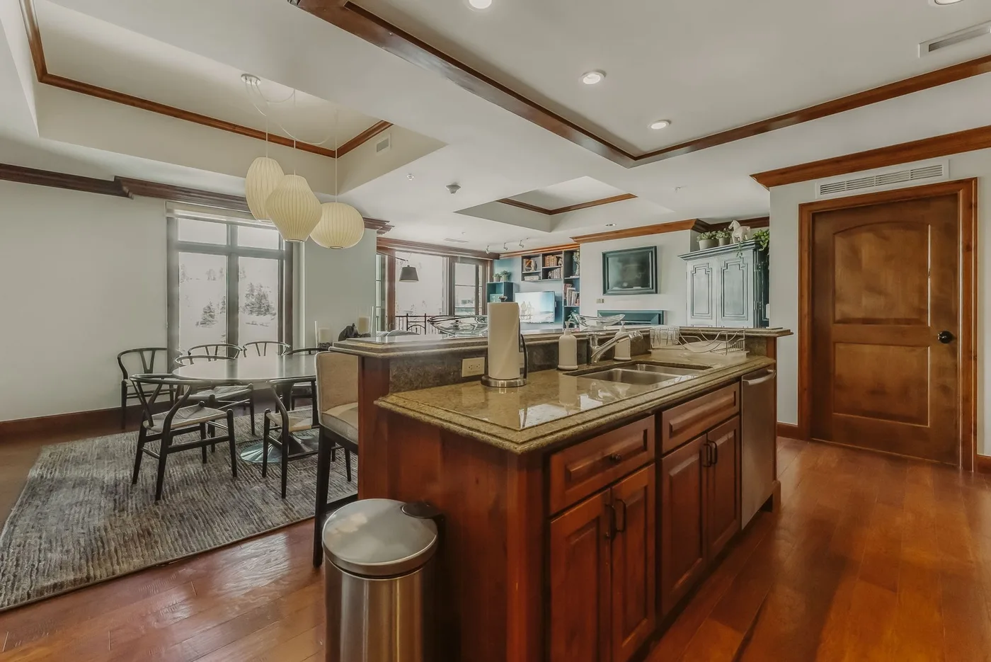 Una cocina amplia con una isla central y una mesa de comedor junto a las ventanas.