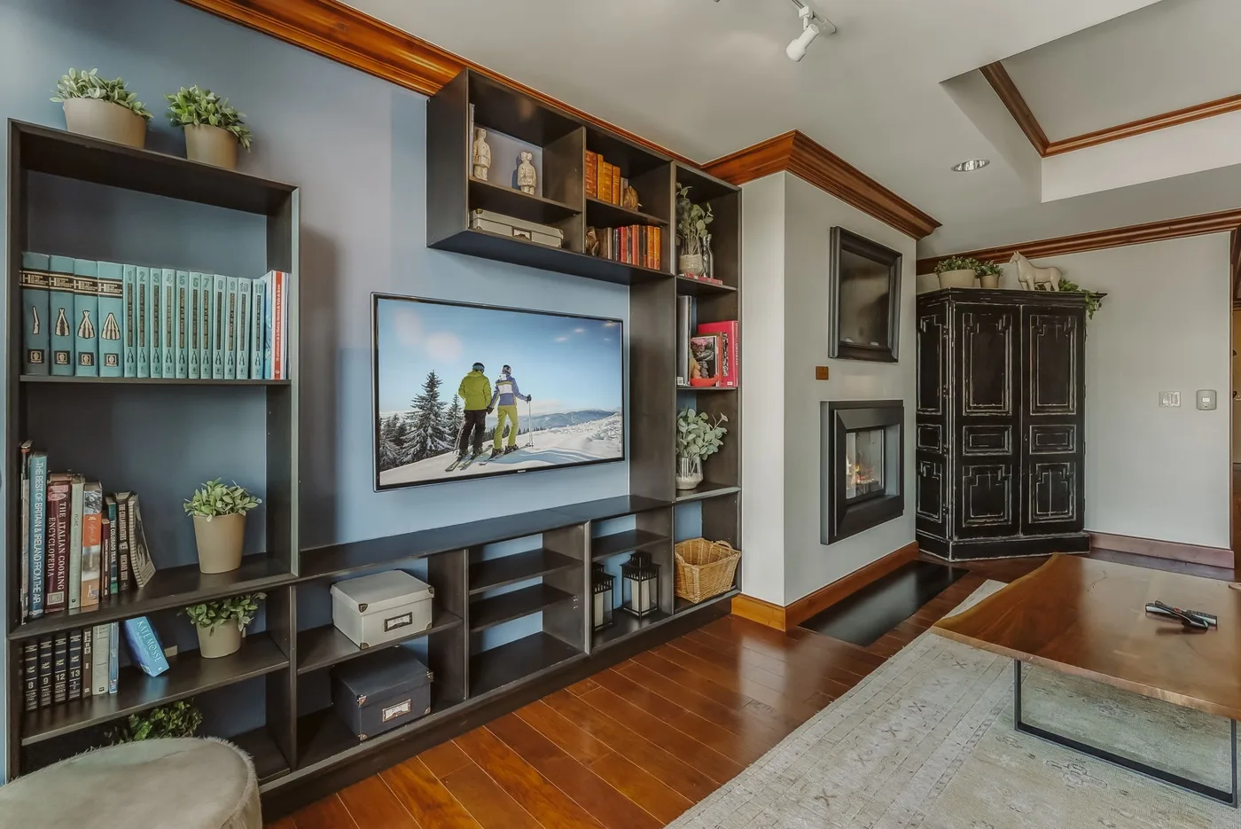 Una sala de estar con estanterías empotradas, una chimenea y un televisor.