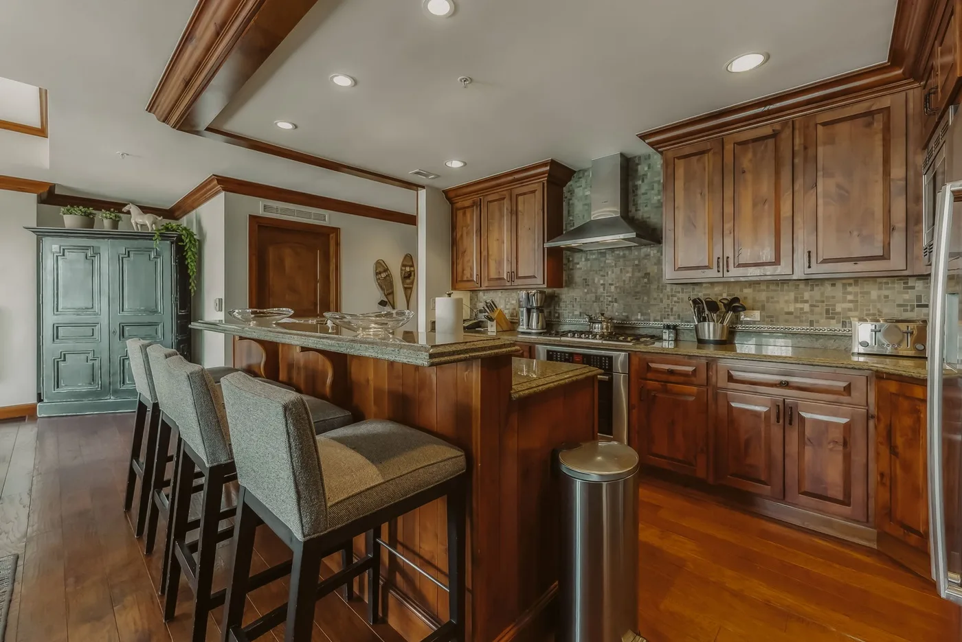 Una cocina amplia con gabinetes de madera, una isla central y asientos de bar.