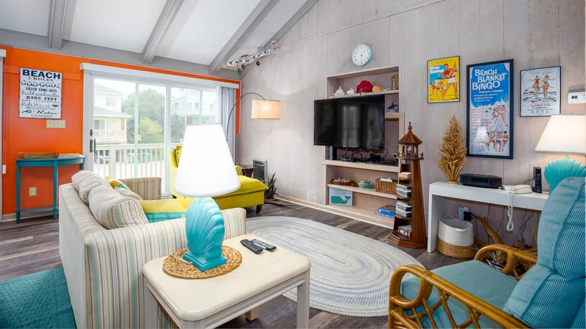 A bright living room with seating, a television, and a large window.