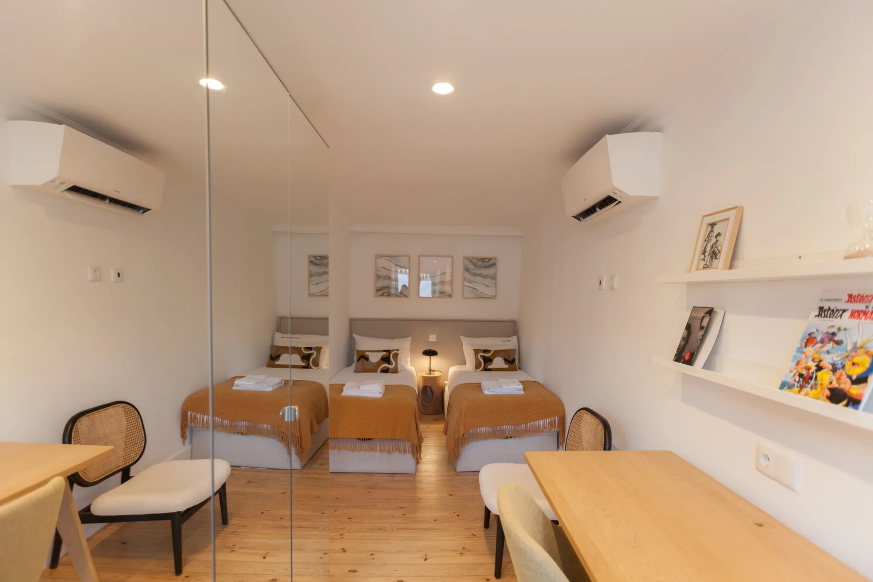 Un dormitorio con camas, mesas auxiliares y una mesa de comedor.