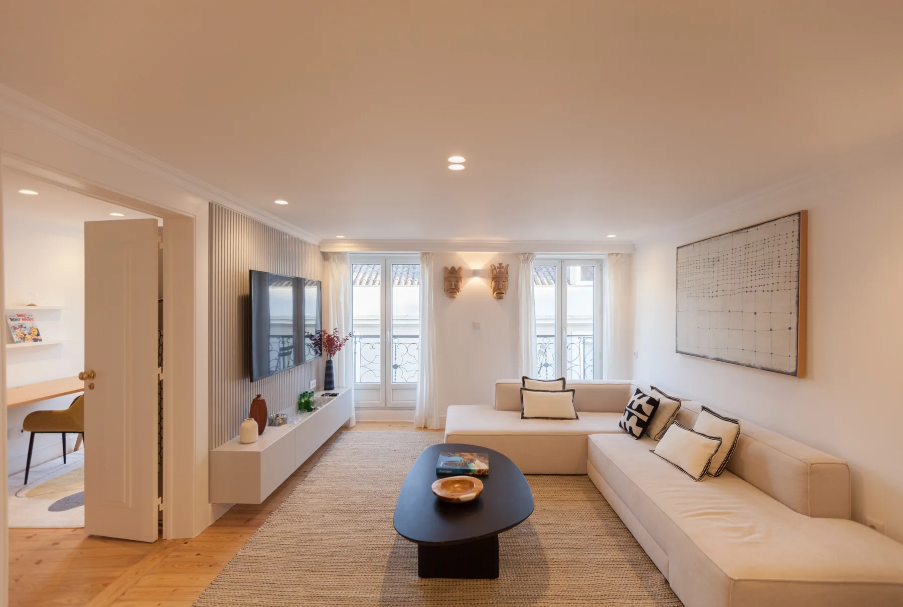 Una sala luminosa con una zona de asientos y una mesa de centro baja.