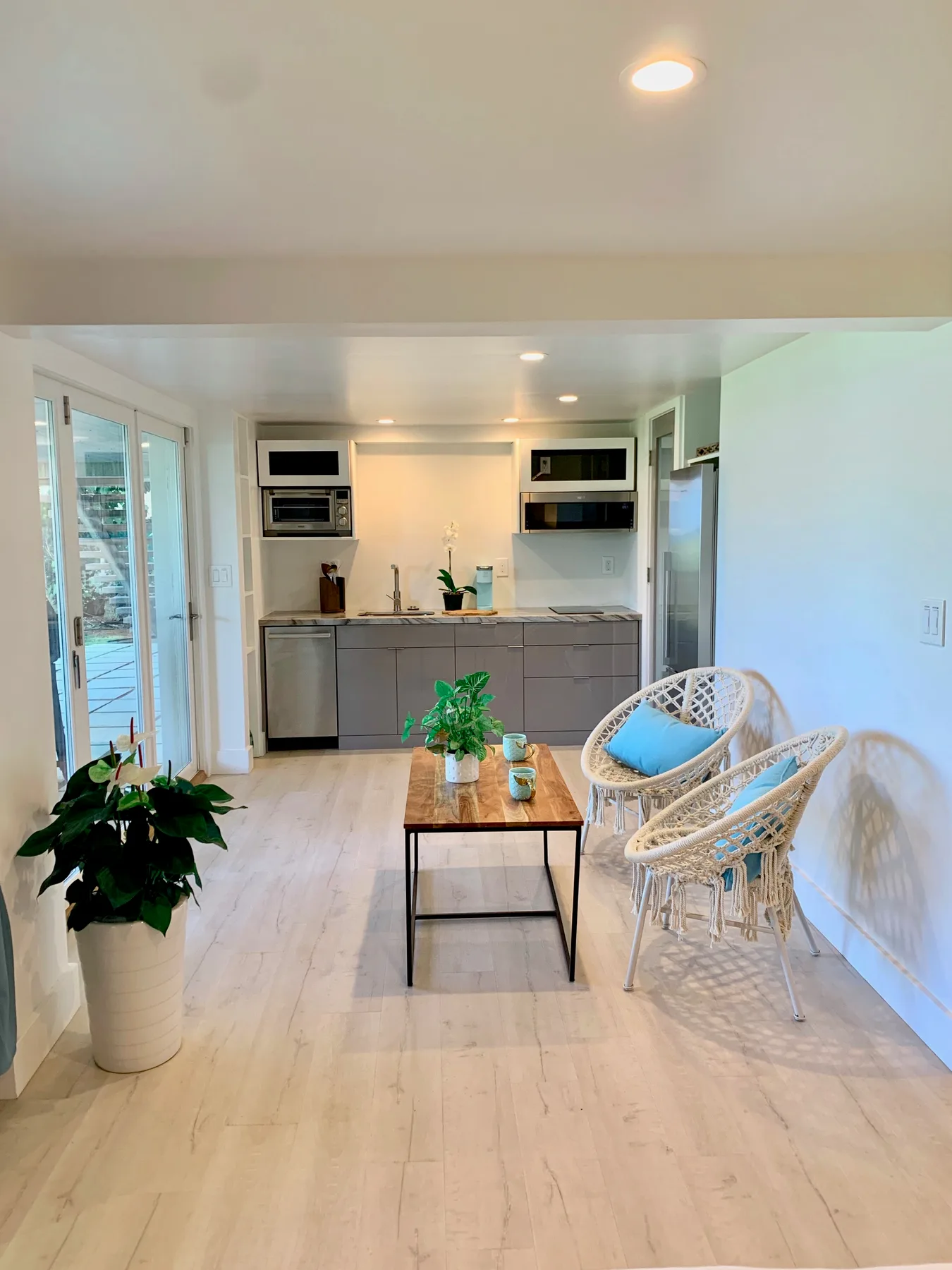 Una cocina y comedor luminosos con una mesa y asientos tejidos.