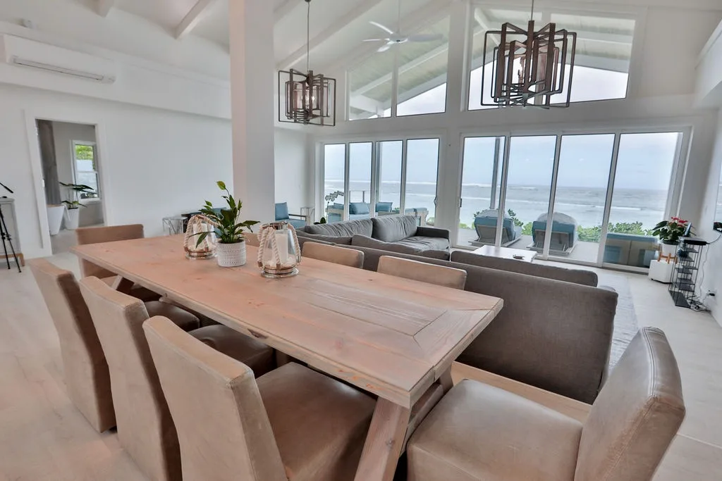 Un luminoso comedor y sala de estar se abren a grandes ventanas con vista al océano.