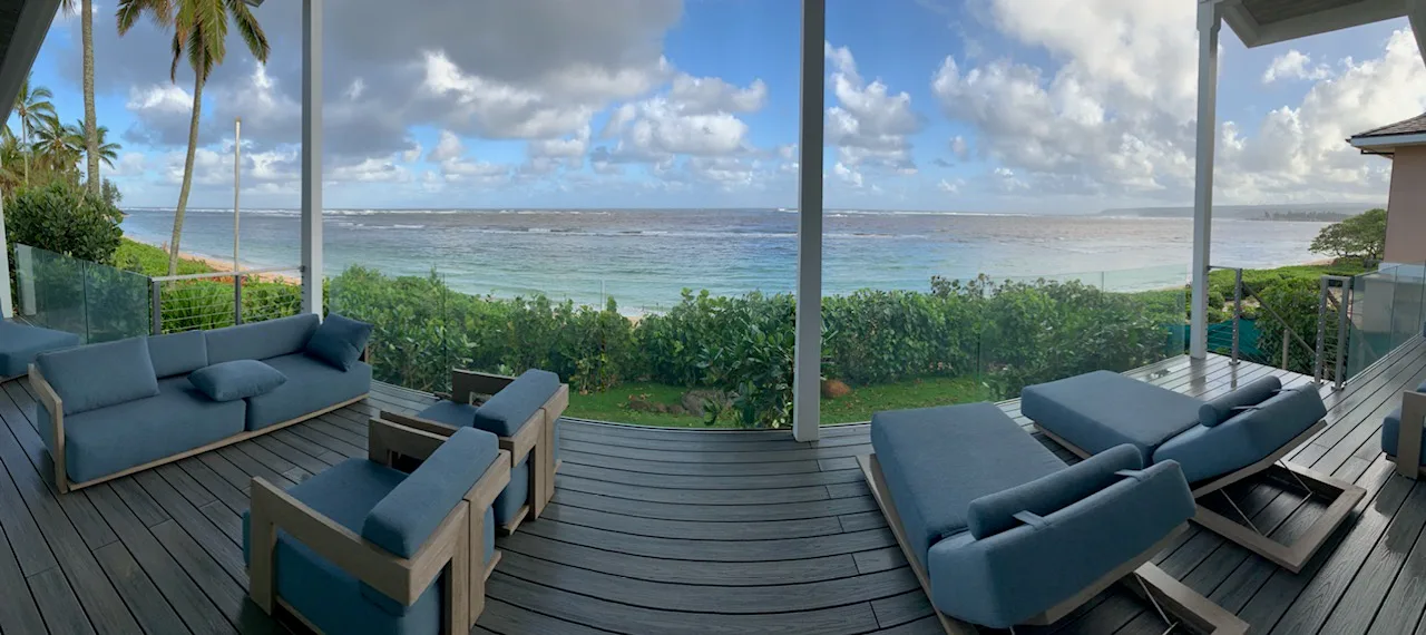Una terraza junto al mar con asientos azules da al océano.