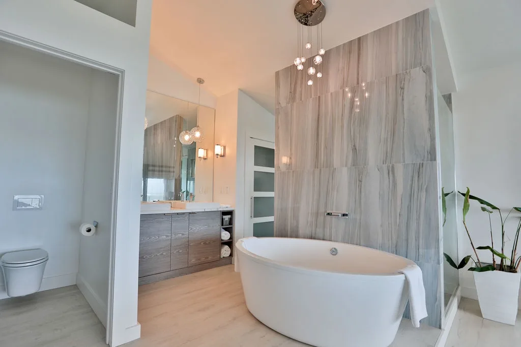 Un baño moderno con una bañera exenta y un lavabo con mueble.