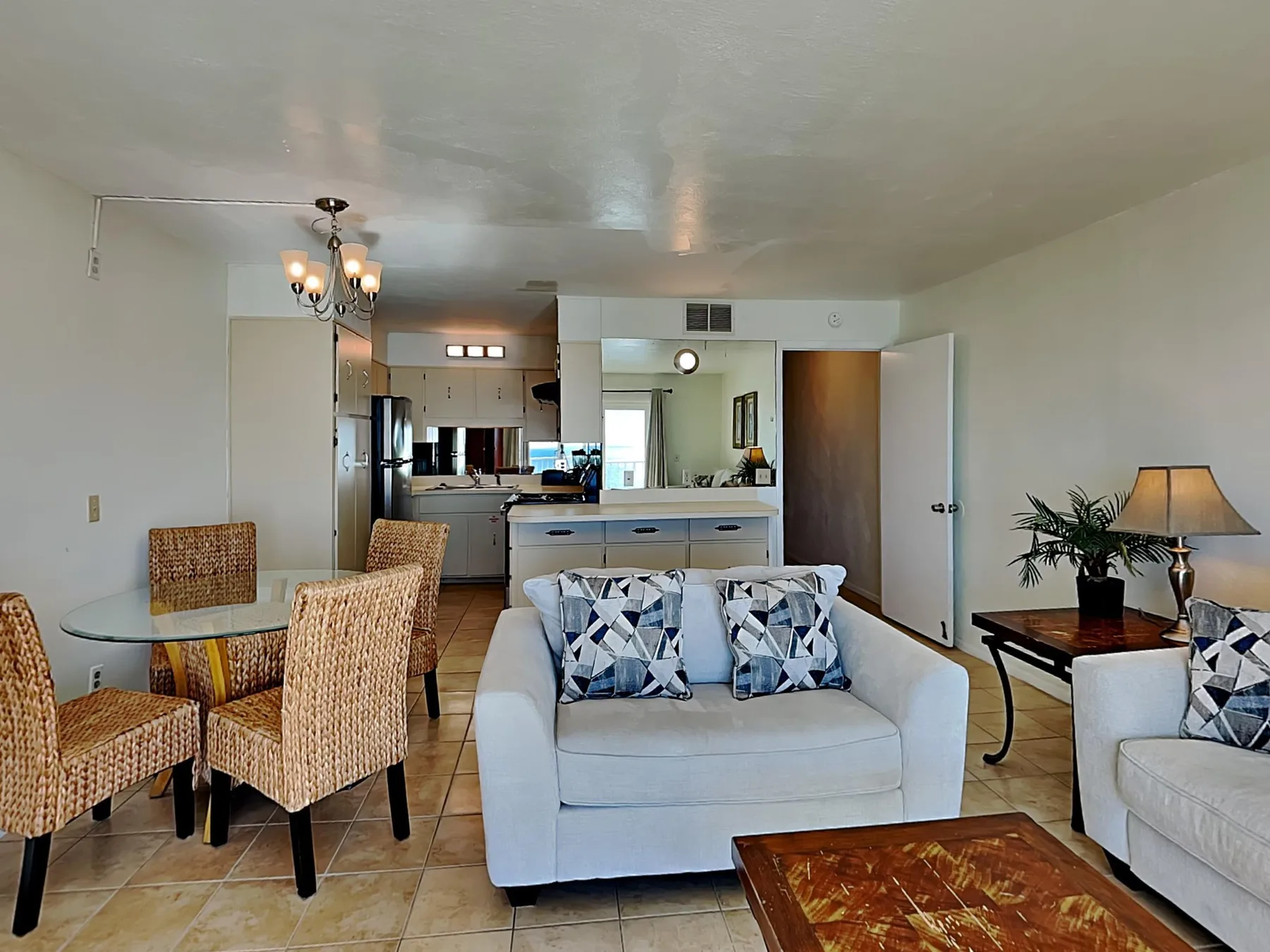 An open-plan living and dining area with a sofa and a kitchen beyond.