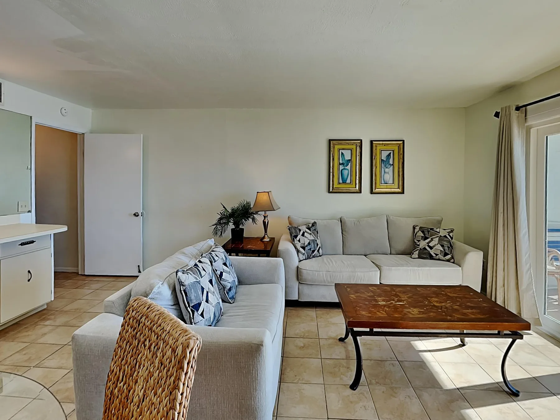 A living room with seating, a coffee table, and framed pictures on the wall.