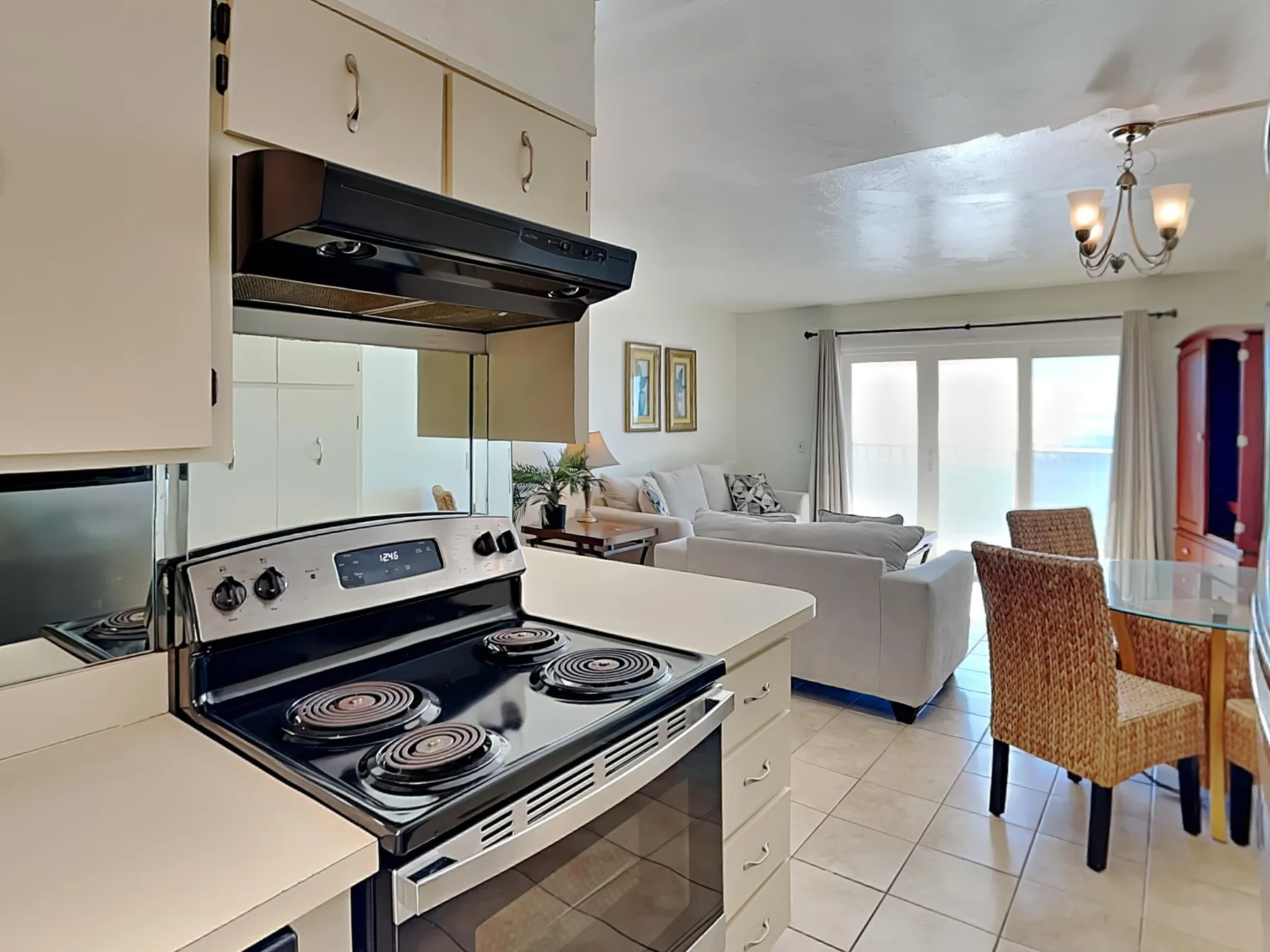 An open-plan kitchen and living area with a dining table beside the windows.