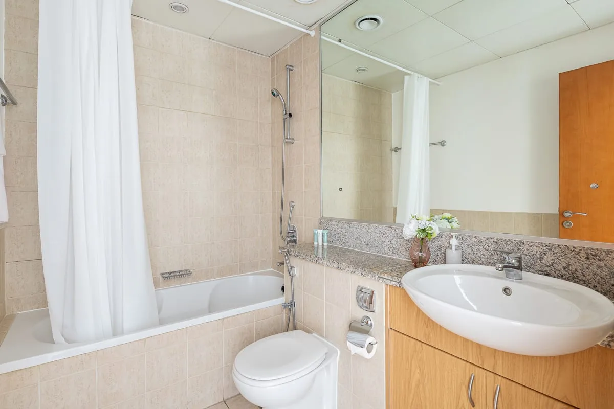 Un baño con bañera, ducha, inodoro y lavabo.