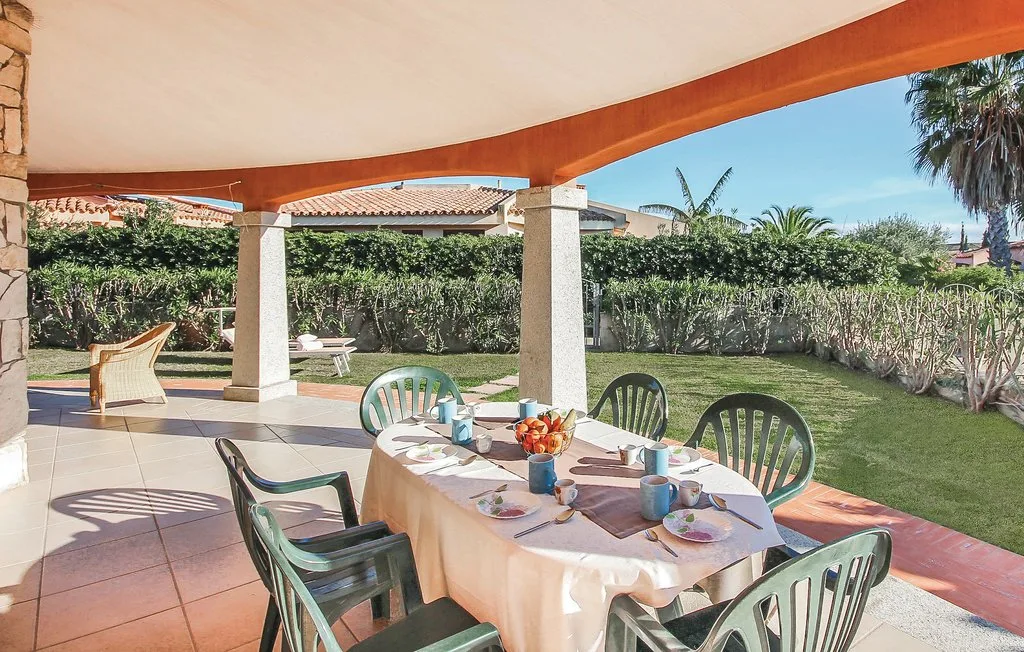 A covered patio dining area opens onto a garden with outdoor seating.