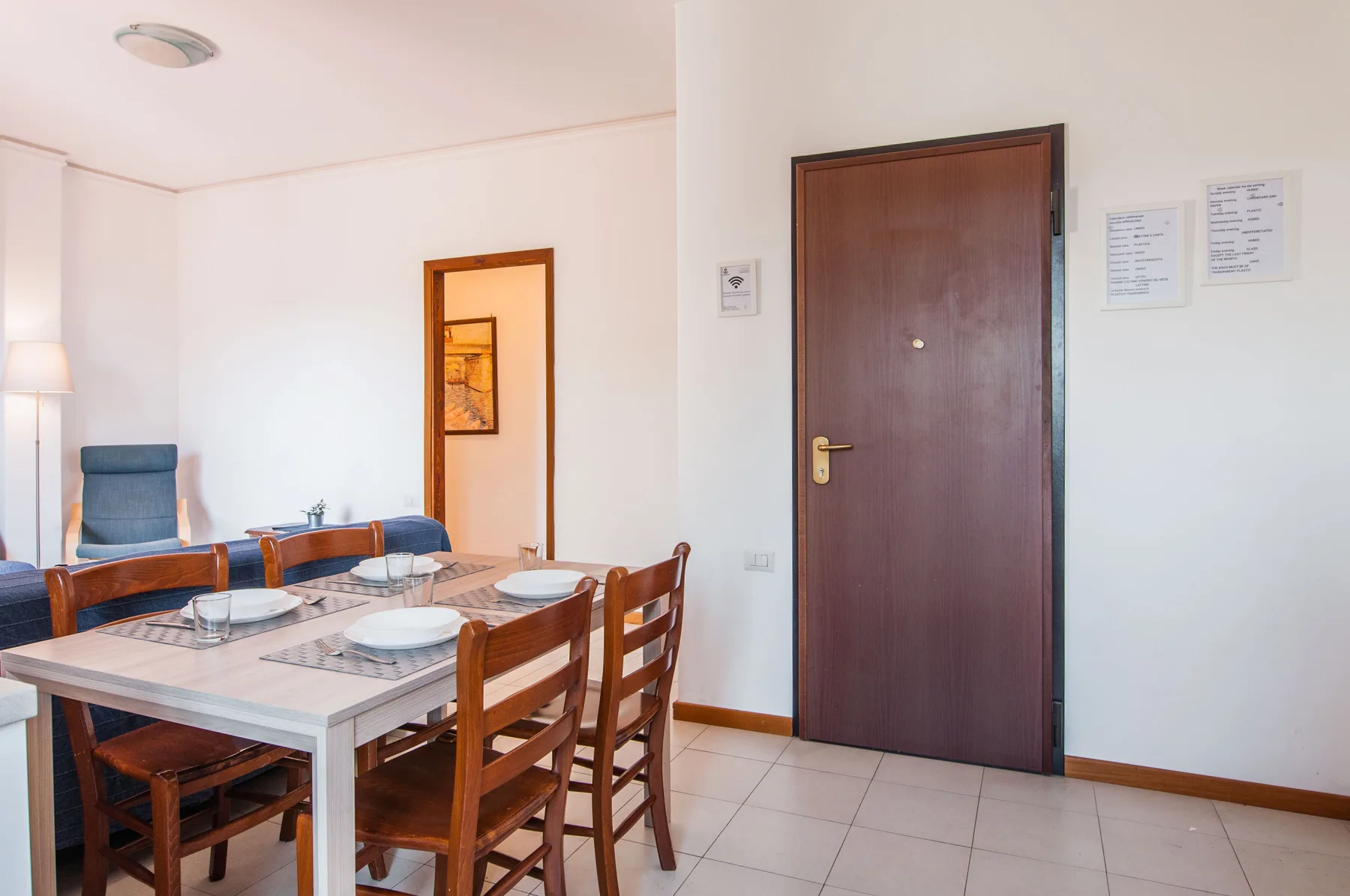 A dining area with a table and wooden chairs beside a closed door.