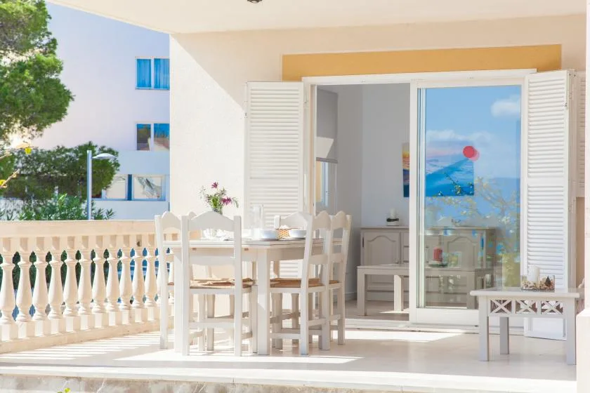 Un comedor luminoso da a un balcón, con una mesa junto a amplias puertas de vidrio.