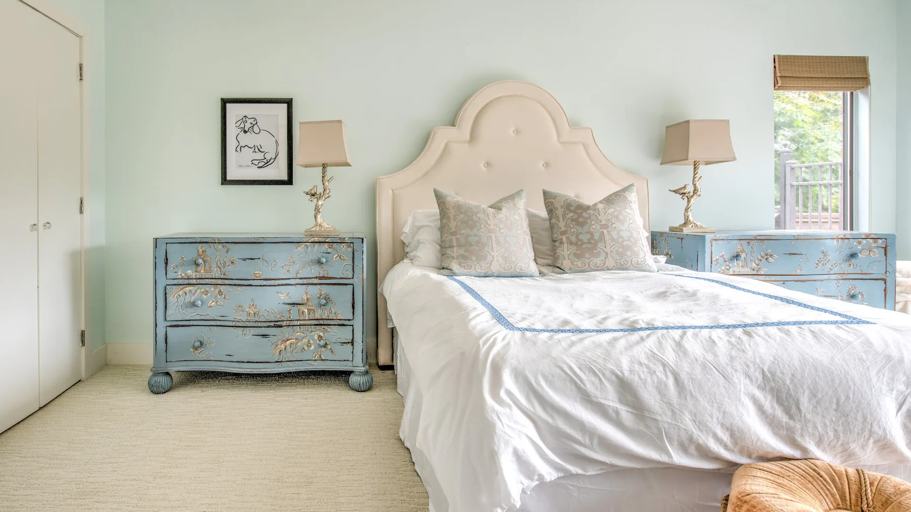 Un dormitorio con una cama entre dos cómodas azules.