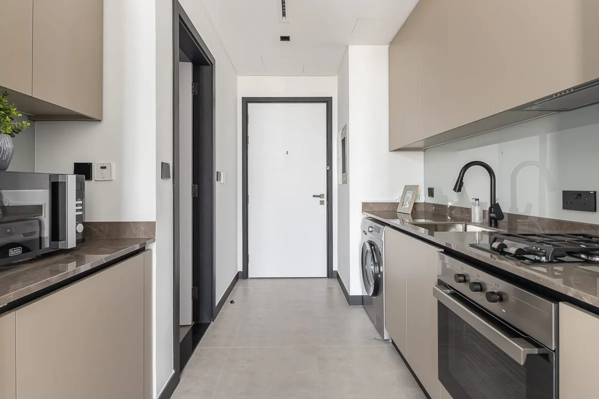 A modern kitchen with a countertop, cooktop, and washing machine.