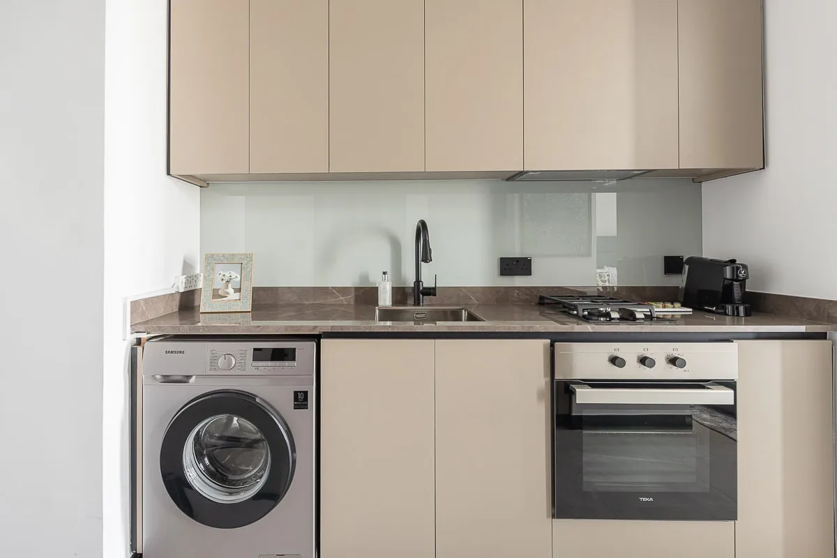 A compact kitchen with a washing machine beneath the counter.