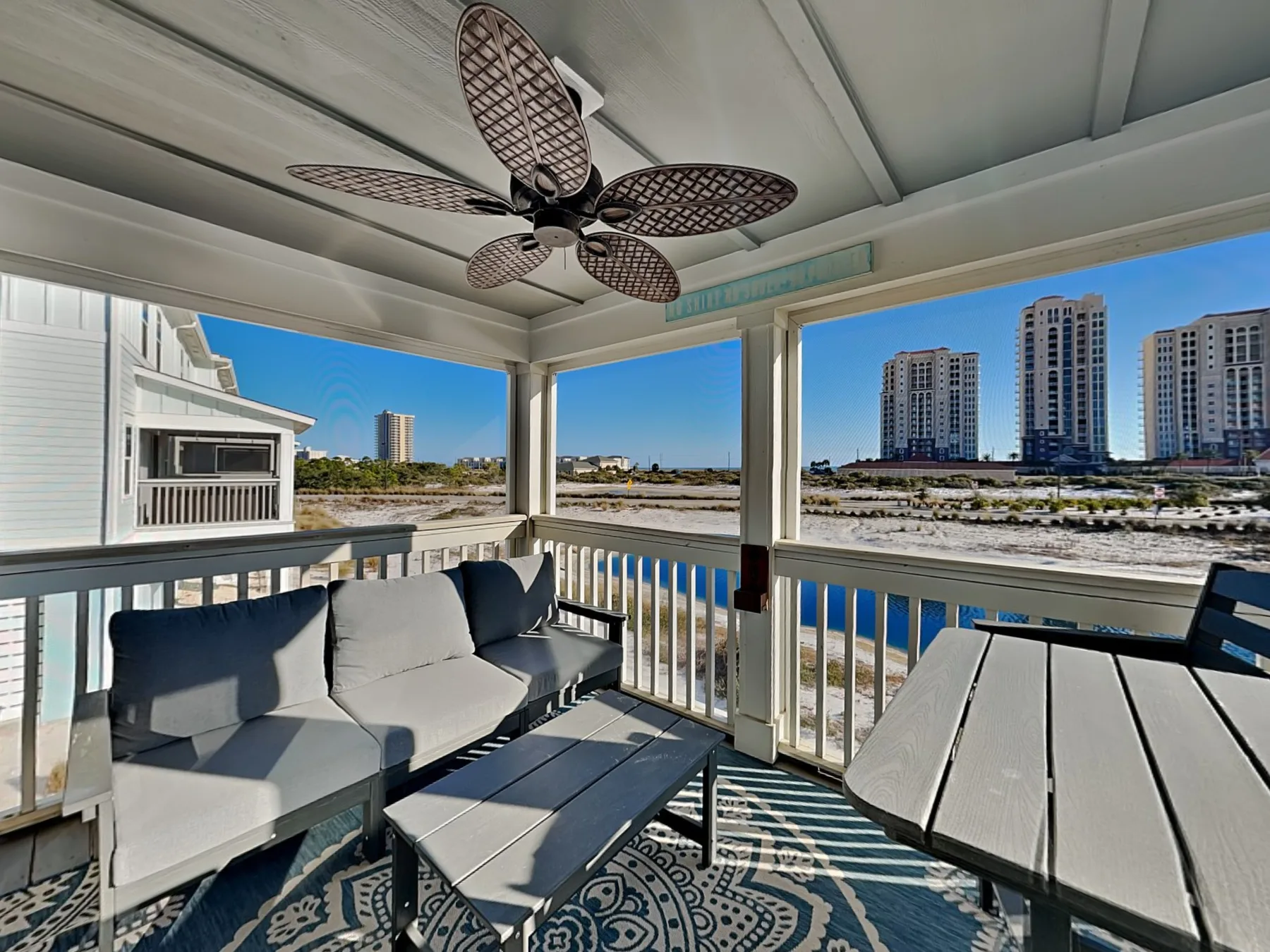 A covered outdoor seating area overlooks the water and nearby buildings.