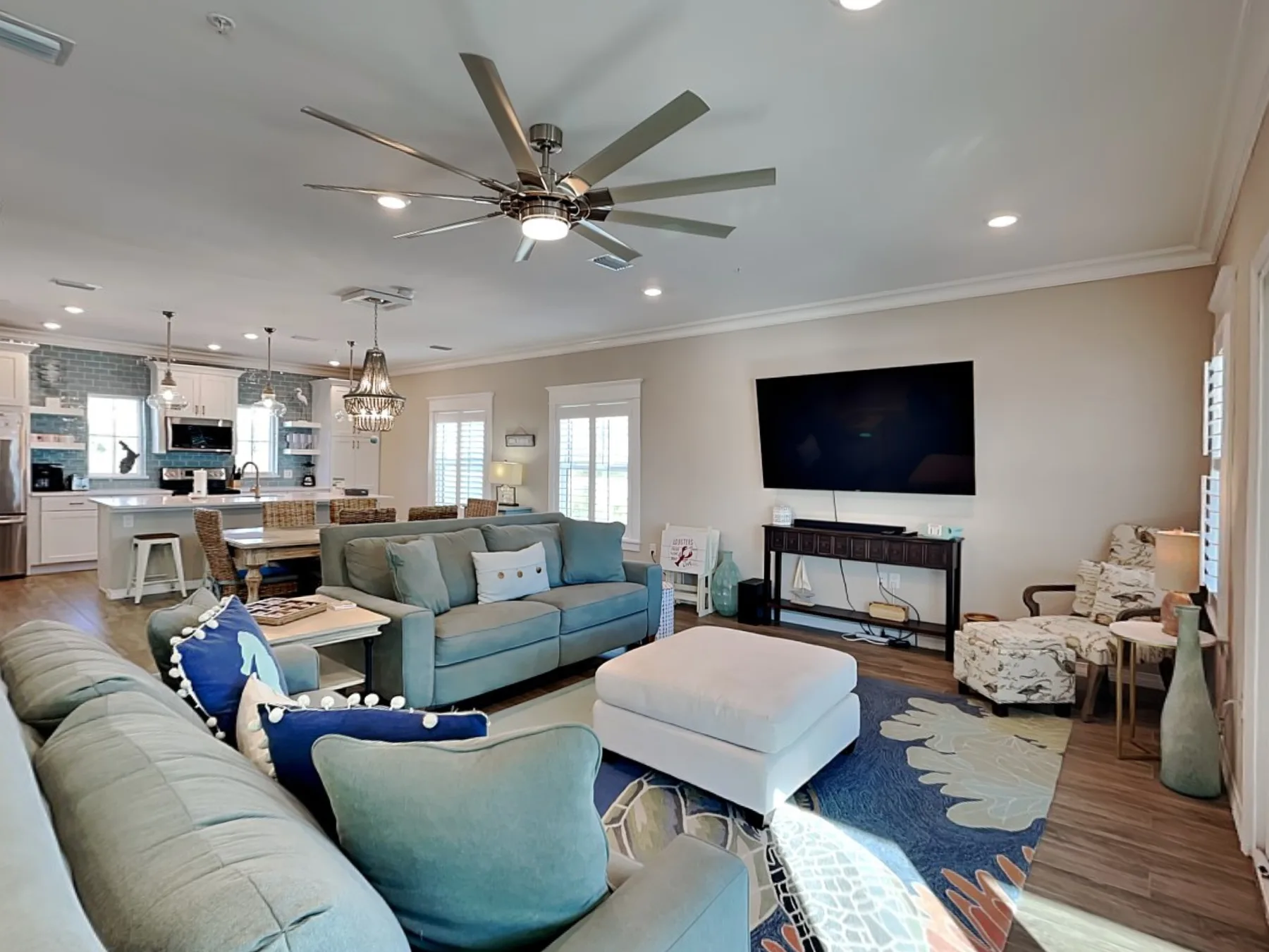 A living room with seating arranged around a coffee table and television.
