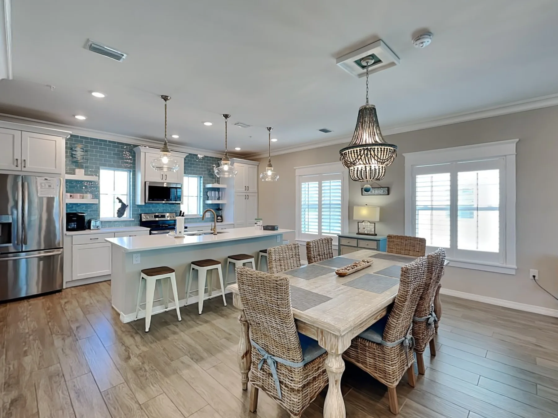 A bright kitchen and dining area with a central island and a long dining table.