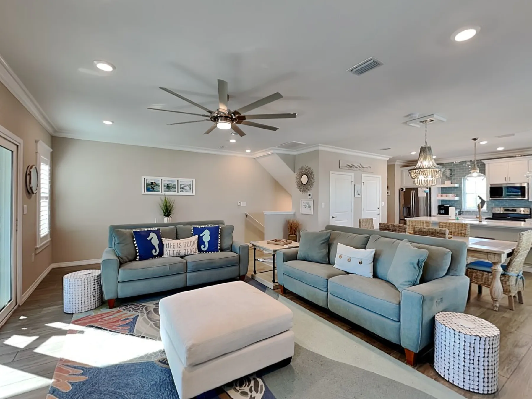 A living room with blue seating and a large ottoman.