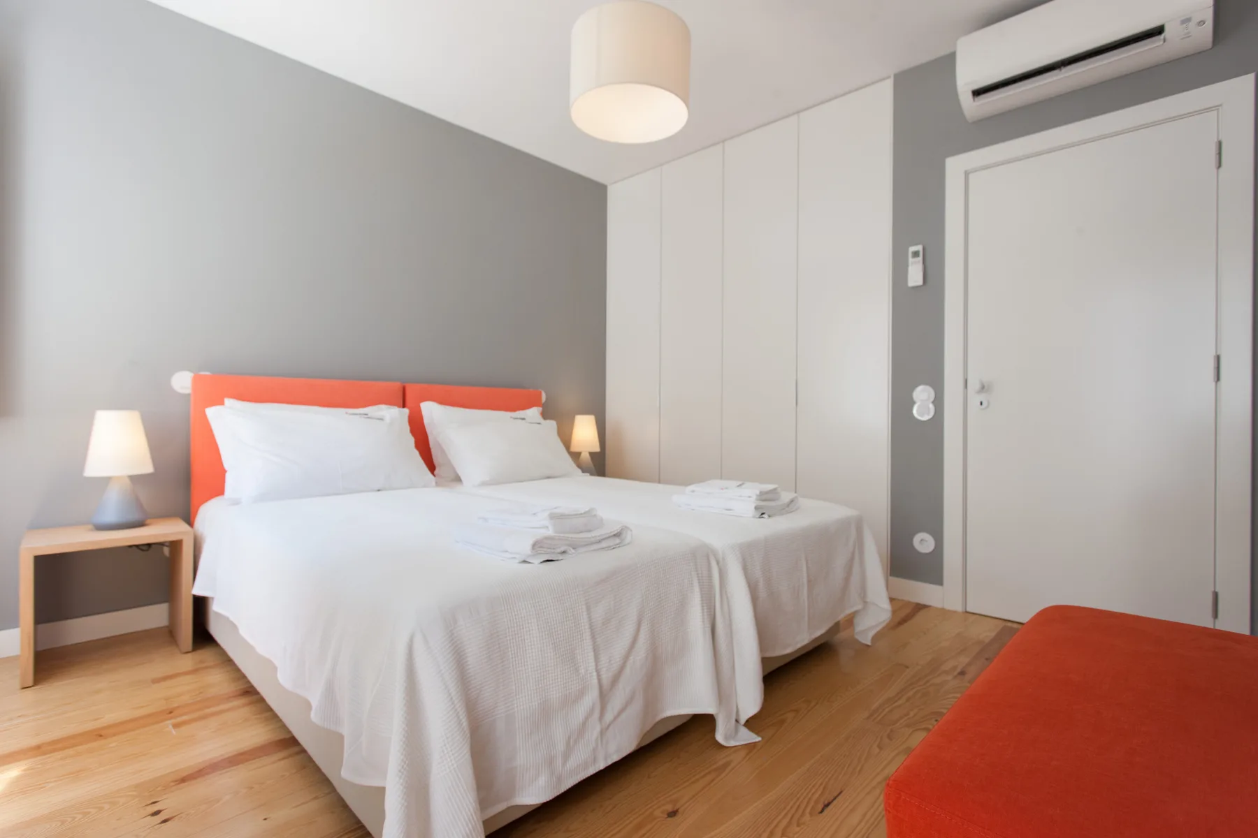 Un dormitorio con una cama bien hecha y mesas de noche.