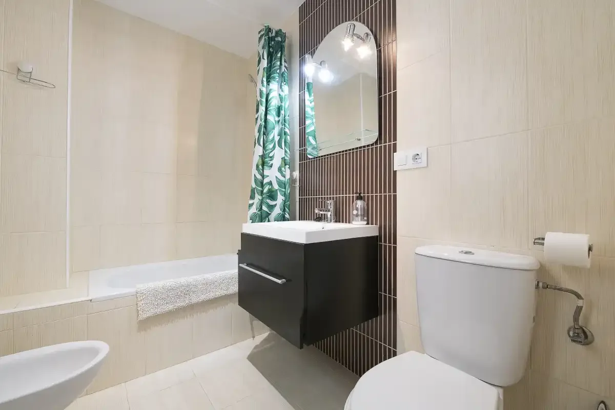 A bathroom with a bathtub, vanity, and toilet.