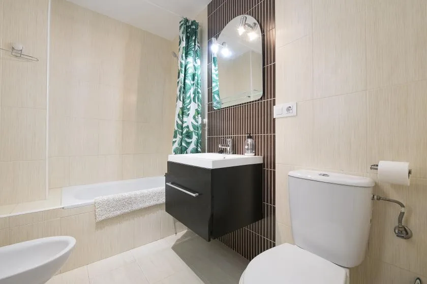 A tiled bathroom with a bathtub, sink, and toilet.