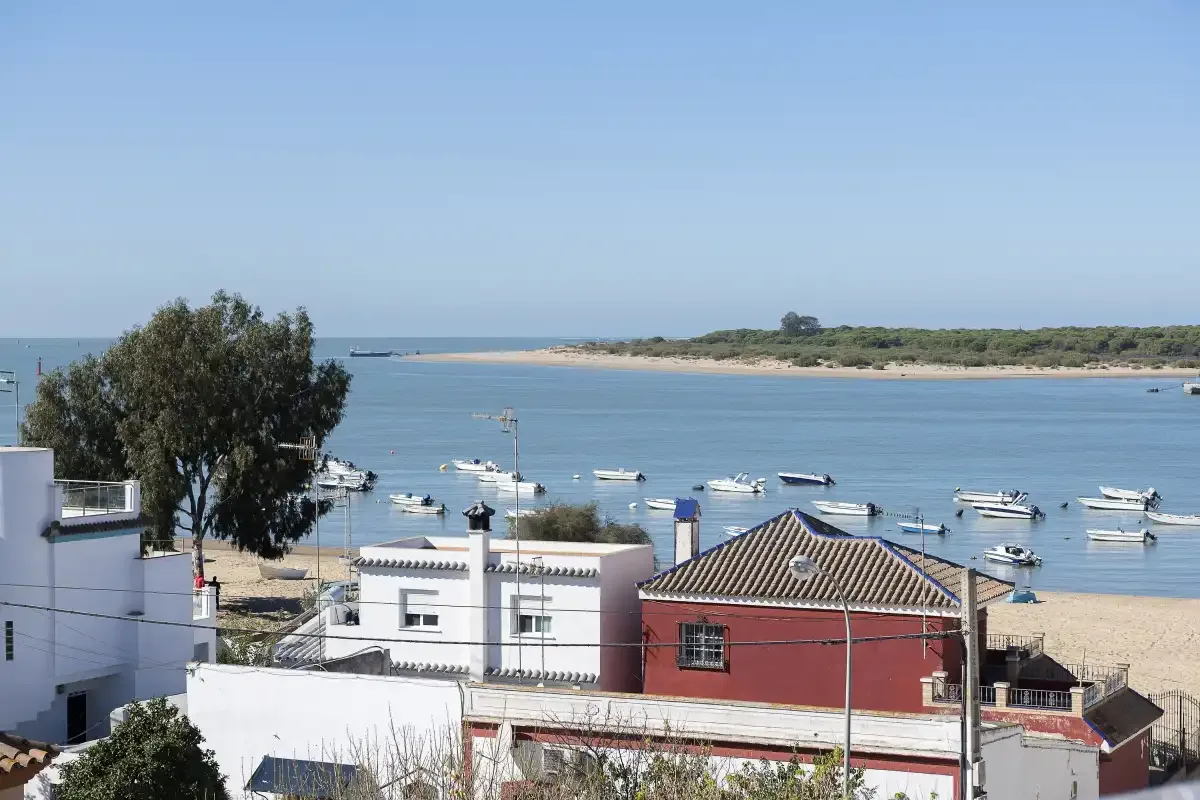 A coastal scene with boats on the water and buildings along the shore.