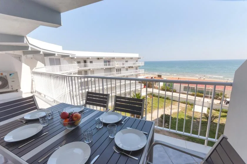 A balcony dining area overlooks the beach and ocean.