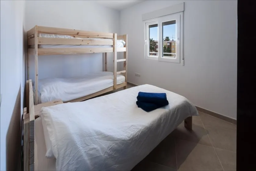 A bedroom with a wooden bunk bed and a double bed.