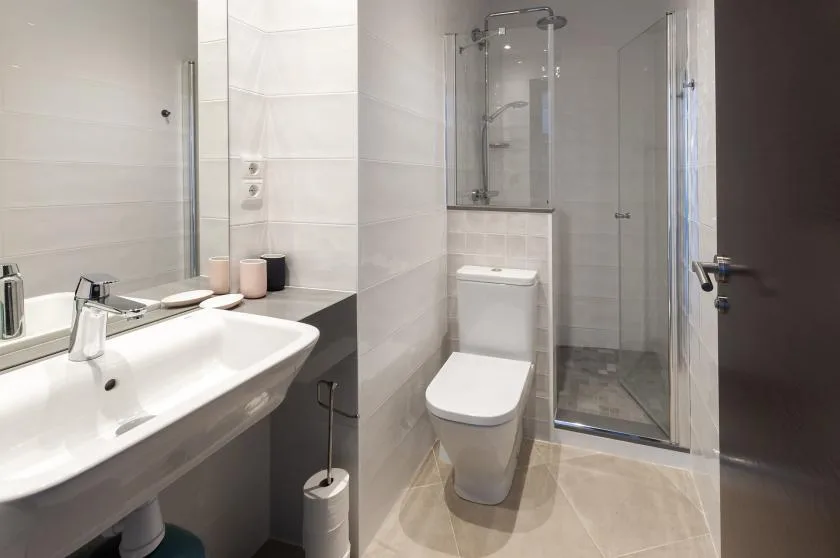 A modern bathroom with a sink, toilet, and glass shower.