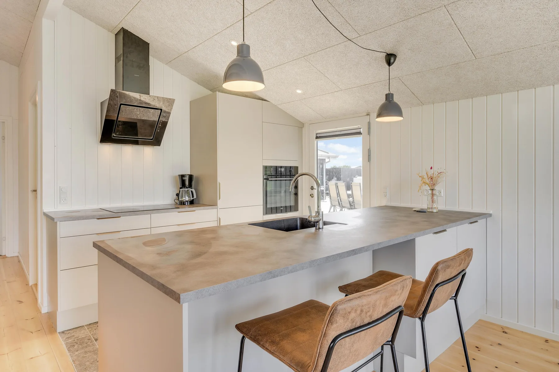 Una cocina luminosa con una isla grande y asientos.