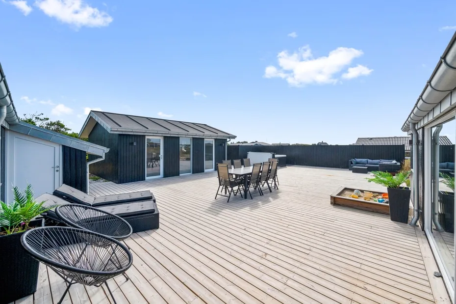 Una amplia terraza en la azotea tiene una mesa de comedor, asientos al aire libre y un cobertizo pequeño.