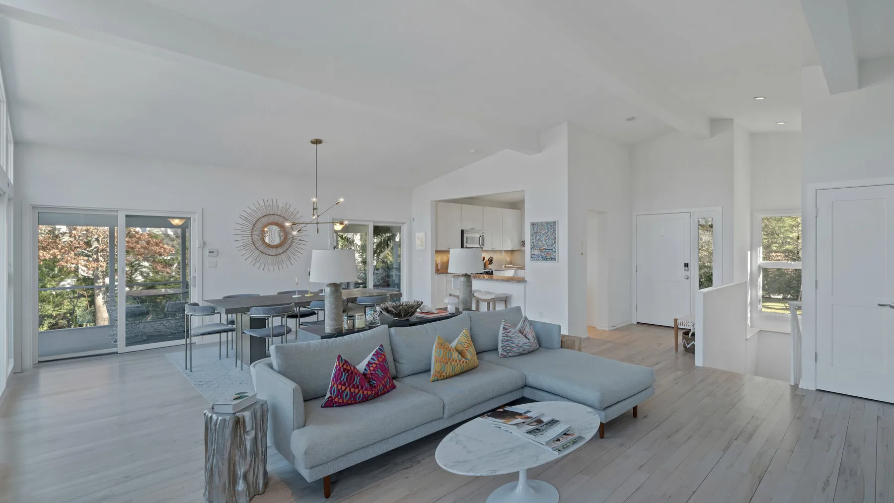 A bright open-plan living and dining area with a sectional sofa and dining table.