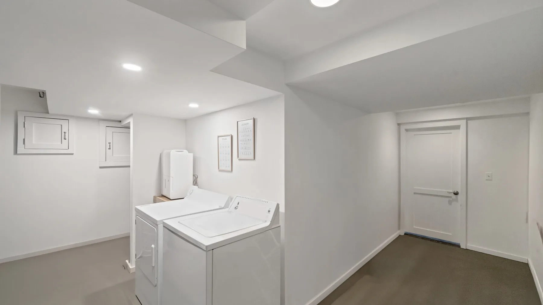 A laundry room with a washer and dryer beside a closed door.