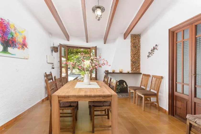 A dining room with a wooden table and chairs beside a fireplace.