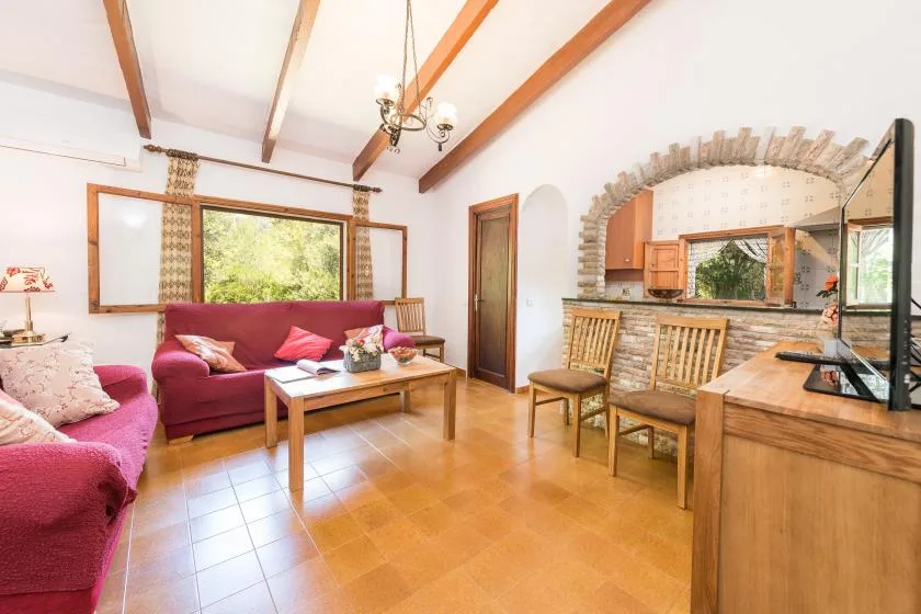 A living and dining area with pink seating and a wooden dining table.