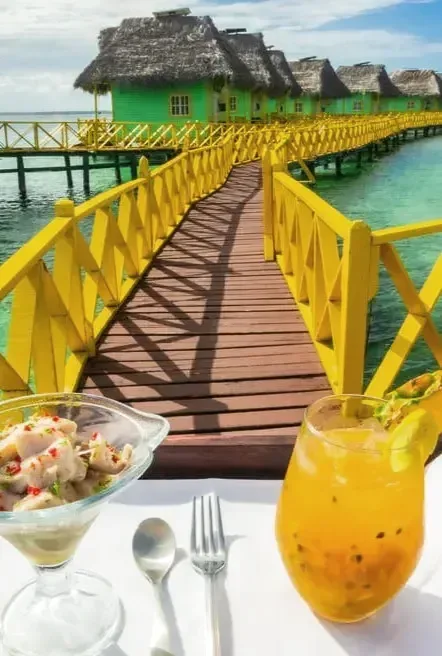 Bebida y ceviche en la pasarela amarilla sobre el mar