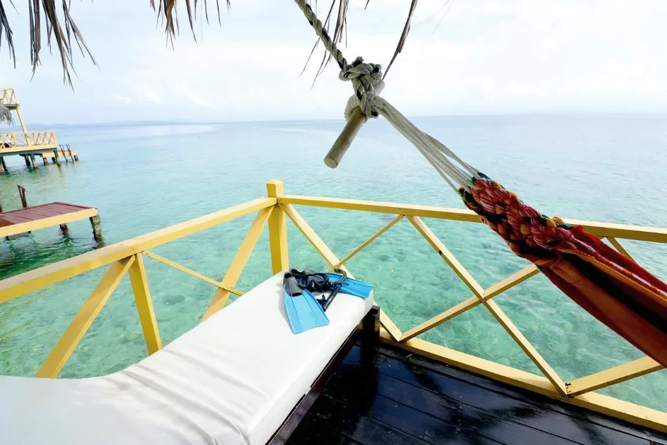 Vista desde la terraza de un palafito con una hamaca sobre el mar Caribe